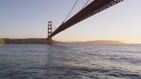 5K stock footage aerial video of flying under the world famous Golden Gate Bridge, San Francisco, California, sunset Aerial Stock Footage | DFKSF10_032