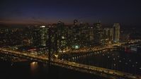 5K stock footage aerial video of flying by the Bay Bridge with a view of skyscrapers in Downtown San Francisco, California, night Aerial Stock Footage | DFKSF14_088