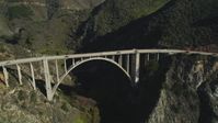 5K stock footage aerial video of flying away from Bixby Creek Bridge above coastal cliffs, Big Sur, California Aerial Stock Footage | DFKSF16_076