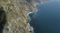5K stock footage aerial video of flying over rocky beach, tilting up along coastal cliffs, Big Sur, California Aerial Stock Footage | DFKSF16_113