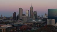 5.7K stock footage aerial video of flying away from and by hotel and city's skyline at sunset, Downtown Indianapolis, Indiana Aerial Stock Footage | DX0001_002941