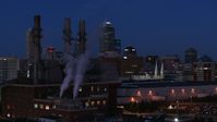 5.7K stock footage aerial video descend by factory smoke stacks with view of the city skyline at twilight, Downtown Indianapolis, Indiana Aerial Stock Footage | DX0001_002977