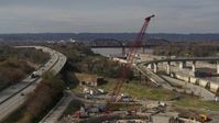 5.7K stock footage aerial video construction crane near railroad bridge and locks and a dam on the Ohio River in Louisville, Kentucky Aerial Stock Footage | DX0001_003017