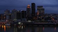 5.7K stock footage aerial video of reverse view of the skyline lit up at twilight, and the Ohio River, Downtown Louisville, Kentucky Aerial Stock Footage | DX0001_003101