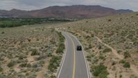 5.7K stock footage aerial video of a black SUV driving by on a desert road in Carson City, Nevada Aerial Stock Footage | DX0001_007_032