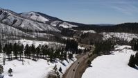 5.7K stock footage aerial video flyby winding road by snowy mountains, reveal black cars, New Mexico Aerial Stock Footage | DX0002_134_033