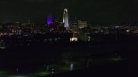 5.7K stock footage aerial video of tall skyscrapers behind the fountain lit up at night, Downtown Omaha, Nebraska Aerial Stock Footage | DX0002_173_052