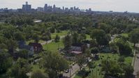 5.7K stock footage aerial video of circling the Heidelberg Project outdoor art display and urban homes, reveal the skyline in Detroit, Michigan Aerial Stock Footage | DX0002_195_009
