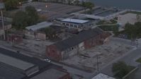 5.7K stock footage aerial video flying away from an abandoned brick building at sunset, Detroit, Michigan Aerial Stock Footage | DX0002_197_052