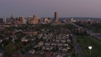 5.7K stock footage aerial video of Seneca One Tower and skyline seen while passing homes at twilight, Downtown Buffalo, New York Aerial Stock Footage | DX0002_204_036