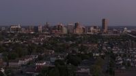 5.7K stock footage aerial video of the skyline seen while flying past homes at twilight, Downtown Buffalo, New York Aerial Stock Footage | DX0002_204_038
