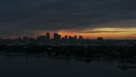 5.7K stock footage aerial video ascending toward Downtown Tampa skyline from the bay at sunset, Florida Aerial Stock Footage | DX0003_231_054