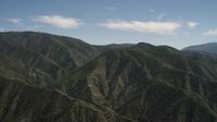 4K stock footage aerial video pan back and forth across green mountains in the San Gabriel Mountains, California Aerial Stock Footage | FG0001_000160