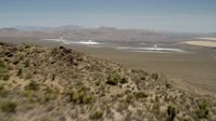 4K stock footage aerial video fly over a desert mountain to reveal the Ivanpah Solar Electric Generating System in California Aerial Stock Footage | FG0001_000171