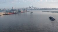 4K stock footage aerial video tilt to reveal barge near the Crescent City Connection Bridge at sunrise, New Orleans, Louisiana Aerial Stock Footage | PVED01_020