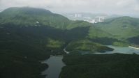 5K stock footage aerial video of Tai Tam Reservoir and green mountain peak on Hong Kong Island, China Aerial Stock Footage | SS01_0075