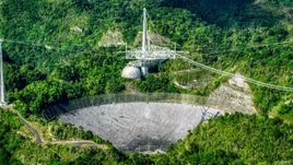 A view of the Arecibo Observatory in the lush green Karst forest, Puerto Rico Aerial Stock Photos | AX101_091.0000000F