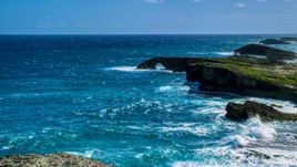 A rock arch in the blue water of a Caribbean island, Arecibo, Puerto Rico  Aerial Stock Photos | AX101_161.0000329F