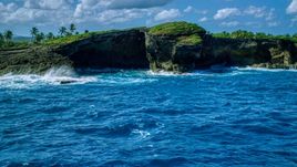 Rock formations on the rugged island coast and crystal blue water, Arecibo, Puerto Rico  Aerial Stock Photos | AX101_165.0000040F