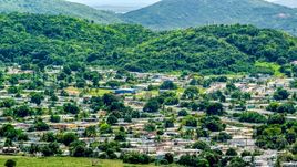 Homes at the base of tree covered hills, Fajardo, Puerto Rico  Aerial Stock Photos | AX102_056.0000000F