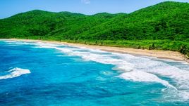 Waves rolling toward a Caribbean beach with lush vegetation, Culebra, Puerto Rico  Aerial Stock Photos | AX102_116.0000269F