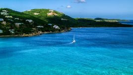 A sailboat near the Caribbean island coast with upscale homes, Southside, St Thomas  Aerial Stock Photos | AX102_234.0000000F