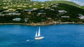 Sailboat near the island coast and oceanfront homes in Southside, St Thomas, the US Virgin Islands  Aerial Stock Photos | AX102_234.0000199F