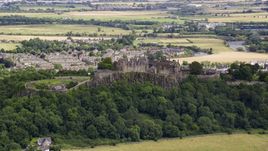 A view of hilltop Stirling Castle among trees, Scotland Aerial Stock Photos | AX109_019.0000084F
