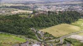 Historic Stirling Castle sitting atop a tree covered hillside, Scotland Aerial Stock Photos | AX109_022.0000135F