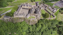 Iconic Stirling Castle and a tree covered hillside, Scotland Aerial Stock Photos | AX109_043.0000155F