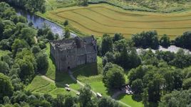 Riverfront Doune Castle with trees, Scotland Aerial Stock Photos | AX109_067.0000164F