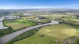 The River Forth near warehouses and green farm fields in Fallin, Scotland Aerial Stock Photos | AX109_102.0000000F