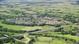 Farm fields and highway M80 by rural village homes, Bonnybridge, Scotland Aerial Stock Photos | AX109_172.0000093F
