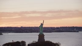 Statue of Liberty with a view of Brooklyn at sunrise, New York Aerial Stock Photos | AX118_041.0000196F