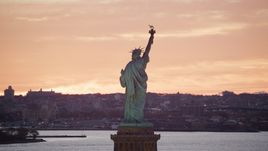 Statue of Liberty with a view of Brooklyn at sunrise, New York Aerial Stock Photos | AX118_042.0000000F