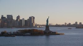 Statue of Liberty and Lower Manhattan skyscrapers at sunrise in New York City Aerial Stock Photos | AX118_132.0000000F