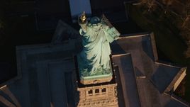Bird's eye view of the Statue of Liberty at sunrise in New York Aerial Stock Photos | AX118_147.0000104F