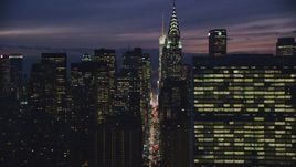 Midtown Manhattan city canyon by Chrysler Building and UN at night in New York City Aerial Stock Photos | AX121_151.0000084F