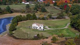 An isolated home with green lawn and colorful autumn trees, Newcastle, Maine Aerial Stock Photos | AX148_011.0000112