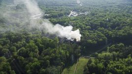 Smoke rising from a burning house in a wooded area, West Atlanta, Georgia Aerial Stock Photos | AX38_054.0000181F