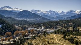 A small town with snowy mountains visible in the distance in Estes Park, Colorado Aerial Stock Photos | DXP001_000217