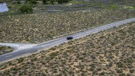 A black SUV parked on a desert road in Carson City, Nevada Aerial Stock Photos | DXP001_007_0002