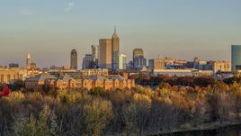 The city's skyline at sunset, seen from trees and apartment complex, Downtown Indianapolis, Indiana Aerial Stock Photos | DXP001_092_0009
