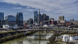A bridge and the river while focused on city skyscrapers in Downtown Nashville, Tennessee Aerial Stock Photos | DXP002_116_0015