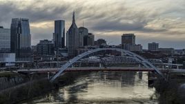 A view of riverfront skyline near a bridge and the Cumberland River at sunset, Downtown Nashville, Tennessee Aerial Stock Photos | DXP002_120_0004