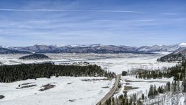Wide view of distant mountains on the other side of a snow-covered valley, New Mexico Aerial Stock Photos | DXP002_134_0009