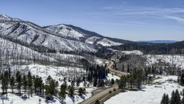 A winding road by snowy mountains, New Mexico Aerial Stock Photos | DXP002_134_0014