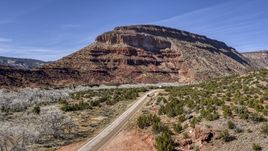 Black car on a desert road near a butte, New Mexico Aerial Stock Photos | DXP002_135_0001