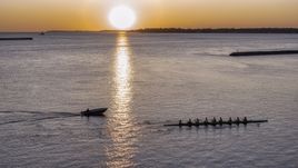 A view of Lake Erie as a rowboat and speedboat pass at sunset, Buffalo, New York Aerial Stock Photos | DXP002_204_0005