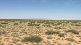 HD aerial stock footage fly low past vegetation in an arid desert plain, New Mexico Aerial Stock Footage | AF0001_000908